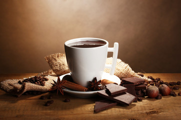 cup of hot chocolate, cinnamon sticks, nuts and chocolate