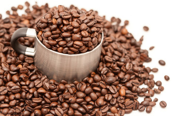 metal mug filled by coffee beans