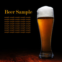Beer into glass on a black and wooden table