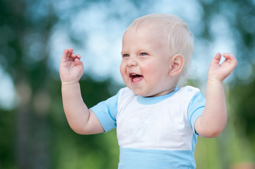 Happy little boy in the green park