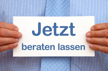 Geschäftsmann mit Schild Jetzt beraten lassen