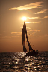 Yacht and sails against the sunset sky