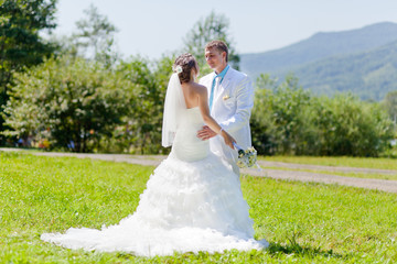 Fototapeta na wymiar Bride and groom hugging at green grass