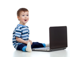 Cheerful child boy using a laptop over white background