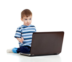 Cheerful child boy using a laptop over white background