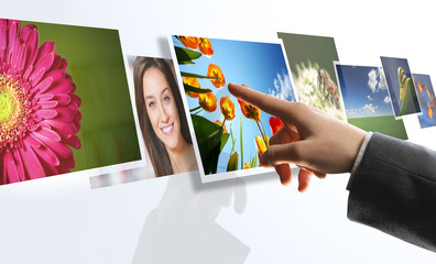 touchscreen interface: man hand reaching images on the screen