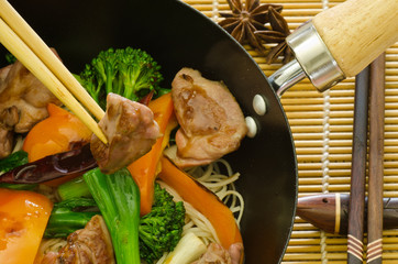wok stir fry of hoisin duck with vegetables and chopsticks