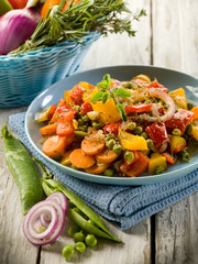 mixed sauteed vegetables on dish over wood background