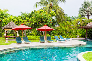 Chaise lounges at pool in hotel in tropics