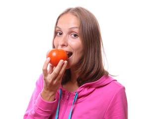 Young woman eating a tomato, isolated