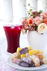 Colorful fruit jelly candy on white plate with juice