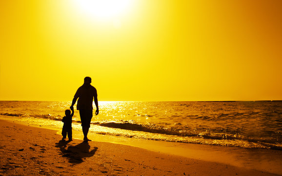 Dad And Child On The Beach At At Sunset