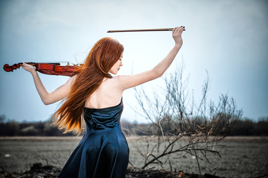 The red-haired girl with a violin outdoor