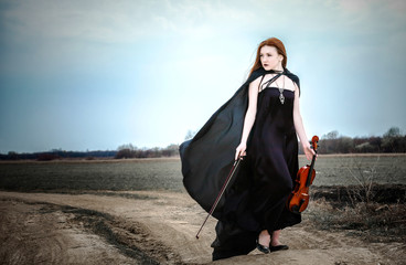The red-haired girl with a violin outdoor