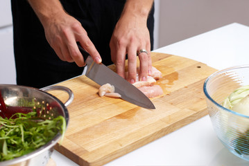 male hands slicing chicken