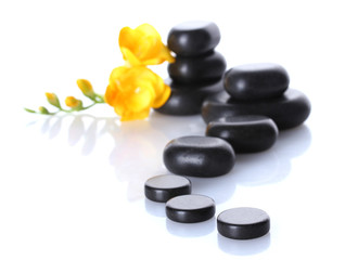 Spa stones and yellow flower isolated on white