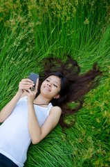 asian cute girl texting on meadow