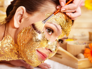 Woman getting  gold facial mask .