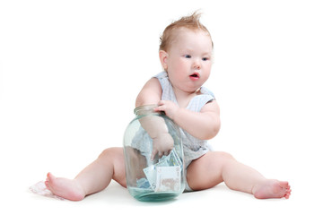 child plays with a glass jar with the money