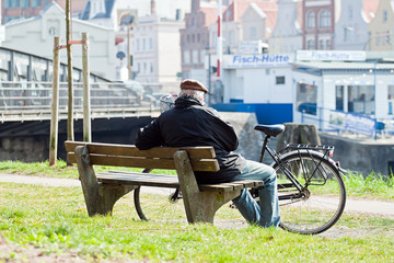 Mann mit Fahrrad auf einer Bank