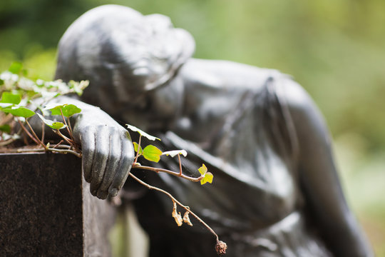 tr&auml;umende Frauenskulptur mit Rose in der Hand