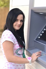 Fototapeta na wymiar Beautiful woman using ATM