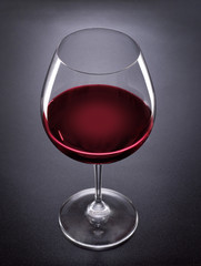 Red wine glass on black background