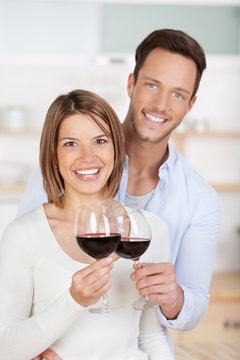glückliches junges paar trinkt rotwein