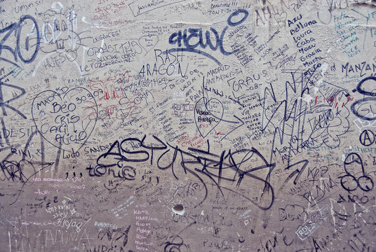 a wall in italy with graffiti and random writings
