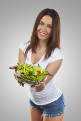 beautiful smiling woman holding a salad over isolated background