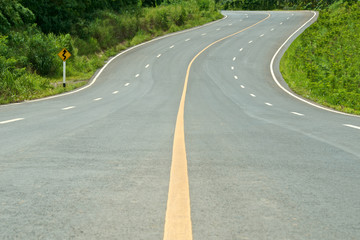 high way curve road with sign and tree on the side