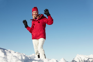 Woman Standing In Snow Wearing Warm Clothes On Ski Holiday In Mo