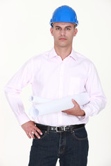 Bald architect stood with plans under arm