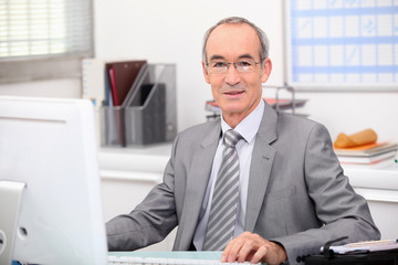 Senior businessman working at a computer