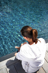 Fototapeta na wymiar Woman sitting by a pool
