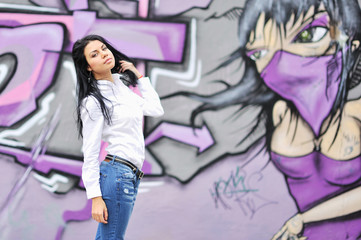 Beautiful girl posing against grafitti wall