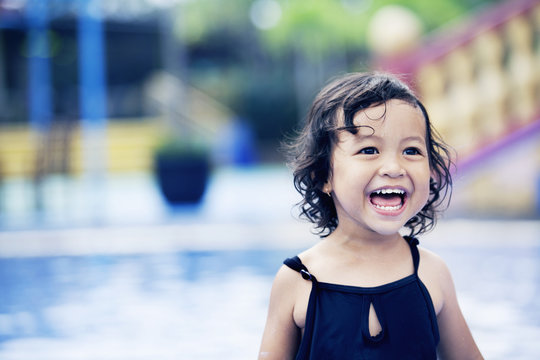 Happy cute girl at swimming pool
