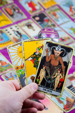 Three tarot cards held in hand (4).
