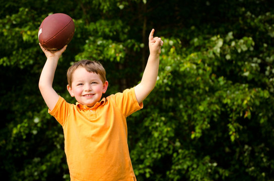 Child With Football Celebrating By Showing That He's Number 1