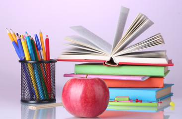 Composition of books, stationery and an apple