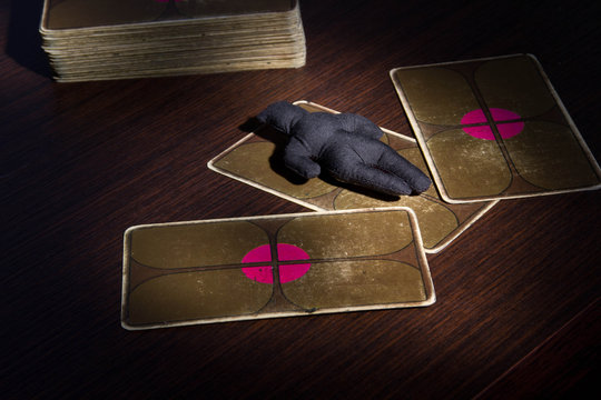 Voodoo doll boy on a table with tarot