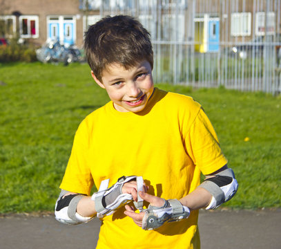 smiling teenage boy in roller-blading protection kit