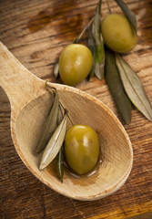 olive in spoon on a wooden table