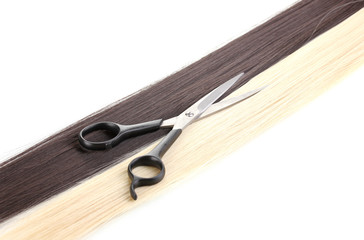 Shiny blond and brown hair with hair cutting shears isolated
