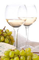 Two glasses of white wine, blue cheese and a grapes