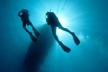Fotobehang Duiken sihlouetted scuba divers