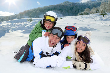 Happy family laying down in the snow