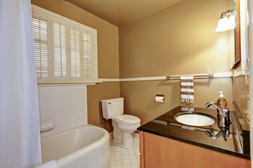 Old brown bathroom with white tub.
