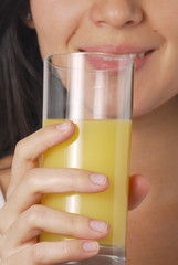 Joven mujer bebiendo jugo de naranja.