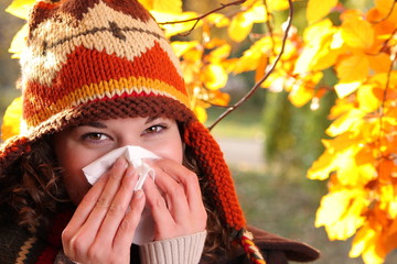 Junge Frau mit Schnupfen im Herbst